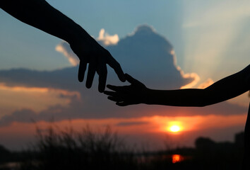 silhouette of  the parent holds the hand of a small child