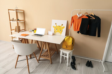 Stylish interior of children's room with modern laptop and school uniform