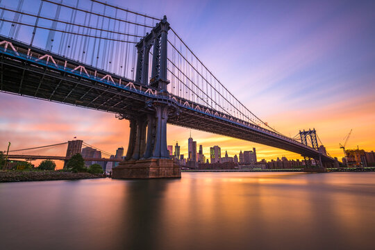 New York City at the Manhattan Bridge spanning the East River during sunset.