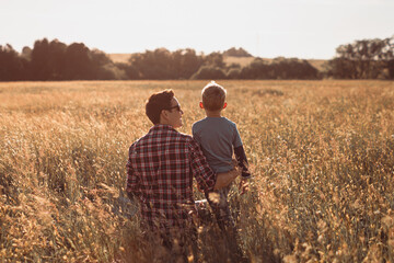 Naklejka na ściany i meble Happy father son moment bonding in nature field celebrating love and togetherness.