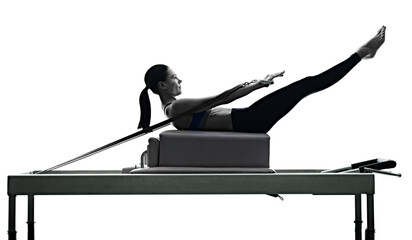 one caucasian woman exercising pilates reformer exercises fitness in silhouette isolated on white...
