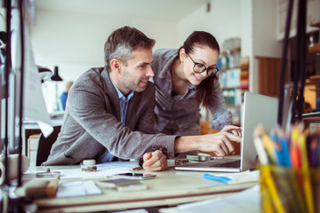 Young man and woman working together on a project in a startup company office