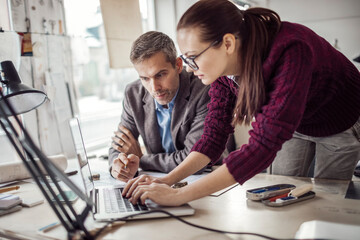 Young man and woman working together on a project in a startup company office