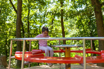 Little girl on the carousel in the park. Selective focus.