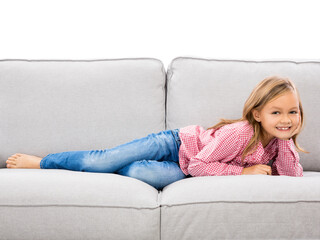 Little girl at home lying on a couch