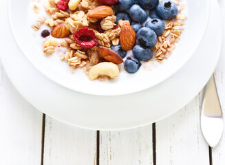 Homemade granola with fruit nuts and fresh yogurt.