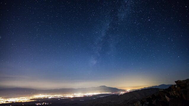 Time-lapse of the night sky. The Lights of Palm Springs California can be seen in the distance.