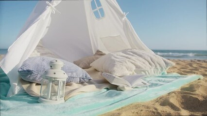 White canvas tent at sea shore beach during sunny summer sunset. Summer vacation and Holiday background with copy space on blue sky. Romantic date and pre wedding background, shot on RED camera slowmo