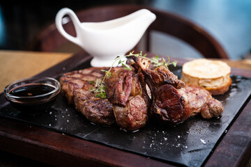 Mixed grilled meat platter. Assorted delicious grilled steaks served with goat cheese on warm dish.