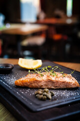 Salmon steak served with pomegranate sauce on a warm plate