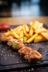 Barbecue grilled pork shashlik kebabs served with french fries