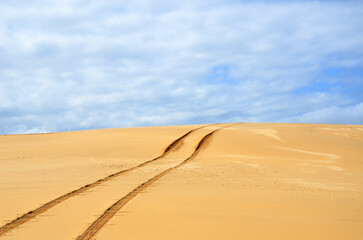 Vehicle tracks over a remote, deserted sand dune near Newcastle, New South Wales, Australia