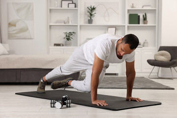 Man doing morning exercise on fitness mat at home