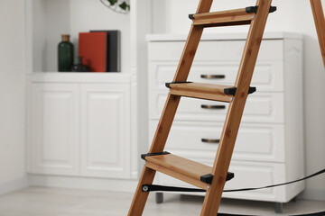 Wooden folding ladder in stylish living room