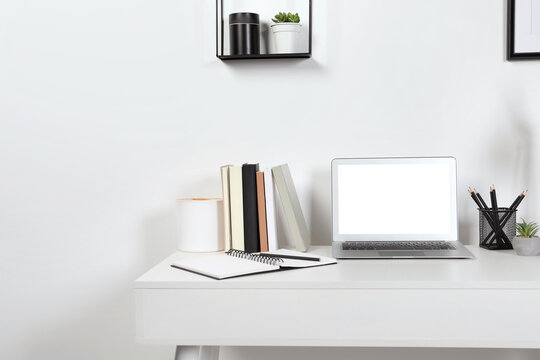 Cozy workspace with laptop and stationery on wooden desk at home. Space for text