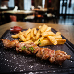 Barbecue grilled pork shashlik kebabs served with french fries