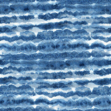 Seamless tie-dye pattern with horizontal stripes of indigo color on white silk. Hand painting fabrics - nodular batik. Shibori dyeing.