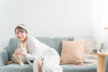 家で猫を抱っこする日本人女性（ペット・飼い主）
