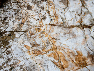 White textured rock wall with brown and orange background