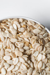 nigerian egusi seeds in a white bowl, shelled melon seeds in a bowl, nigerian melon seeds, pumpkin seeds for cooking