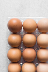 Top view of a crate of eggs on a marble surface, Eggs in a transparent plastic crate, organic eggs on a table
