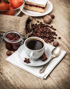 Fragrant strong coffee with sweet dessert and bean on old wooden board in rustic style