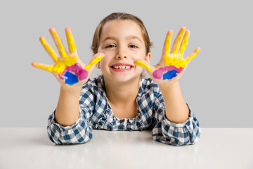 Cute smiling little girl with hands in paint