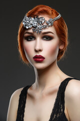 Beautiful young woman with smoky eyes and full red lips. Massive crystal hair accessory on head. Studio beauty shot. Copy space.