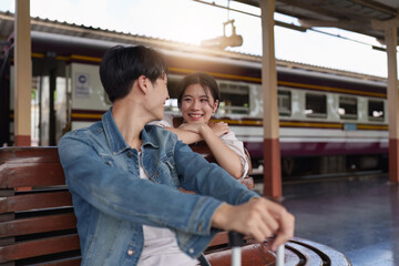Fototapeta na wymiar Asian couple at railway station have happy moment. Tourism and travel in the summer