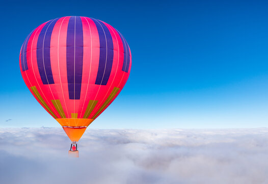 Morning flight of the hot air balloon above the clouds.