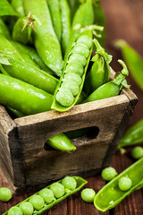 Fresh ripe green peas in wooden box