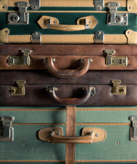 Stack of colorful vintage suitcases, handles close up, travelling concept.