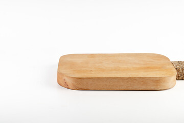 Food preparation tool and kitchen utensils concept with close-up on rectangular wood chopping board with round corners isolated on white background.