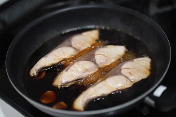 	ブリの煮付けを作る様子
