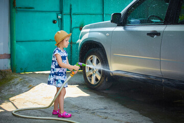 little girl spraying a car with a water hose in a sunny afternoon, rubber hose, pour water on over
