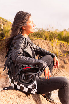 Motorcycle woman rider sitting in the sand