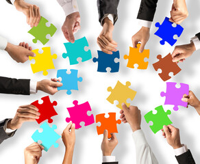 Business people join the colorful puzzle pieces. Concept of teamwork and integration