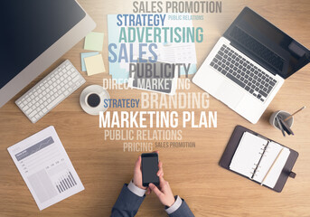 Businessman working at office desk, hands using a smart phone top view, marketing and business text...