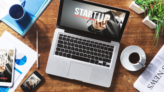 Start up website on laptop, touch screen tablet and smartphone on a desktop