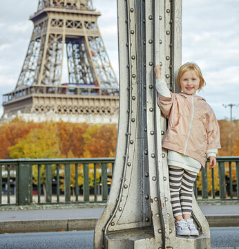 Year round fit & hip in Paris. Full length portrait of happy active child in sport style clothes against Eiffel tower in Paris
