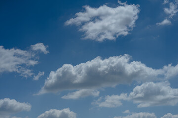 Naklejka na ściany i meble Big white fluffy cumulous clouds on blue sky