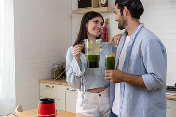 Happy young couple Cooking Healthy Vegetable mixer in Kitchen