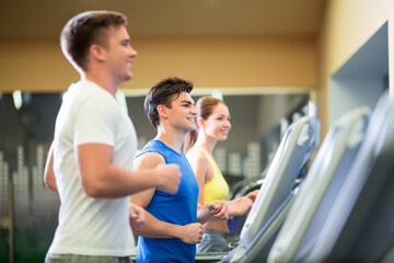 Fototapeta na wymiar Young sportsman at treadmill indoors