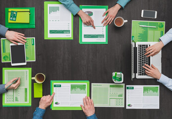 Business team working at desk and examining green financial reports, eco business, ecology and finance concept