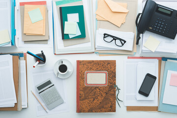 Full business desktop with paperwork, calculator and folders, top view