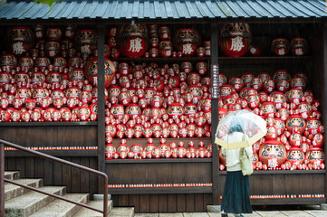 A vibrant image showcasing a crowd of Darumas in the streets of Osaka, Japan. A colorful and...