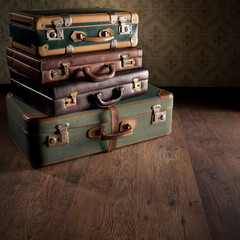 Stack of colorful vintage suitcases on hardwood floor, travelling concept.