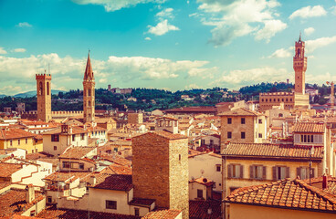 Fototapeta na wymiar Florence Italy old town with houses tegular roofs and high tower on background blue sky vintage stylized