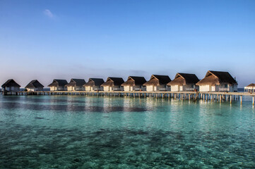Picturesque bungalows on stilts near the shore of a tropical island, Maldives