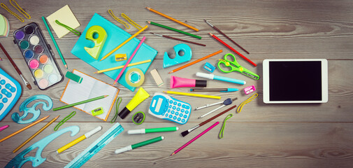Colorful stationery entering a digital tablet, creative tool concept.